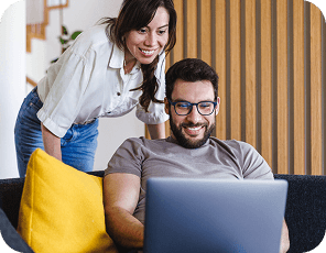 Duas pessoas em um sofá olhando para um notebook